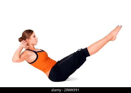 Woman doing yoga exercice appelé : voile pose, nom sanscrit : Navasana, isolé sur fond blanc Banque D'Images