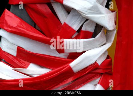 Ruban barrière en plastique rouge et blanc enroulé autour d'un poteau Banque D'Images