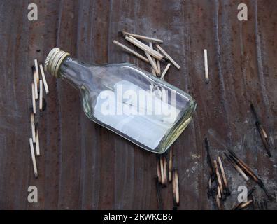 Bouteille de cognac vide avec allumettes brûlées sur une plaque de métal Banque D'Images