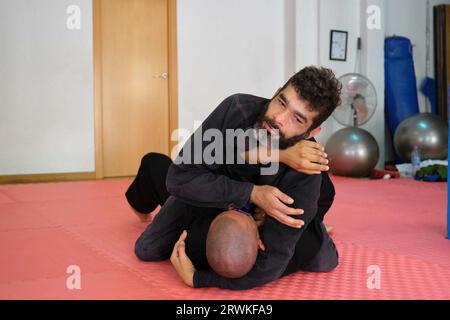 Deux hommes pratiquant le jiu-jitsu brésilien sparring à l'école. Formation BJJ. Banque D'Images