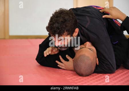 Deux hommes pratiquant le jiu-jitsu brésilien combattant à l'école. Formation BJJ. Banque D'Images