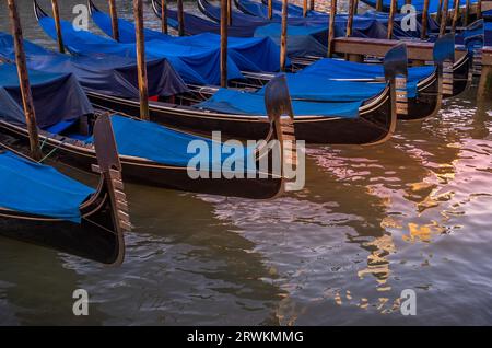 Gondoles bleues et noires amarrées sur le côté du Grand Canal près du pont du Rialto, Venise, Italie Banque D'Images