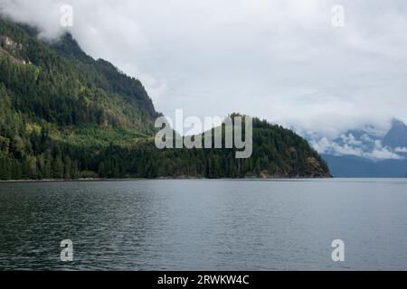 La forêt tropicale luxuriante couvre les eaux calmes de Inland passage entre la côte est de l'île de Vancouver et le continent canadien. Banque D'Images