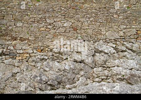 Mur médiéval, composé de pierres brutes taillées, construit sur la roche Banque D'Images