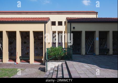 Deux grands garages en briques situés dans une zone herbeuse et pavée, avec des marches menant à eux Banque D'Images