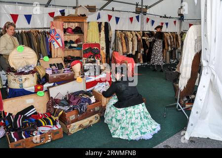 Section « Over the Road » du Goodwood Revival 2012. Tente de vente offrant des vêtements d'époque, des robes, des chapeaux et des articles. Visite du public en train de parcourir le stock Banque D'Images