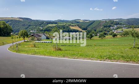 Le paysage du Luxembourg avec un petit village dans la vallée près de la réserve naturelle Mullerthal avec des collines buissonnantes et un landsca agricole Banque D'Images