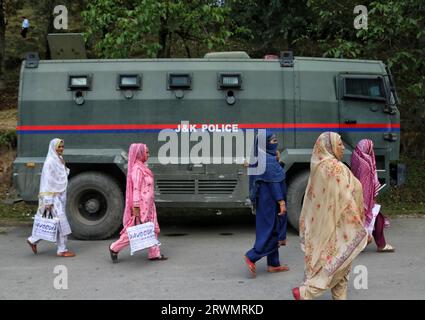 19 septembre 2023, Srinagar Cachemire, Inde : des femmes passent devant un véhicule blindé près du site d'une fusillade entre militants et forces de sécurité dans le village de Kokernag, dans le district d'Anantnag, à Gadole. Le directeur général supplémentaire de la police (ADGP) zone du Cachemire, Vijay Kumar, a déclaré que deux militants, dont le commandant du LET Uzair Khan, ont été tués dans la rencontre. Jusqu'à présent, deux officiers supérieurs de l'armée indienne, un officier de police, un soldat et deux militants, dont le commandant du LET Uzair Khan, ont été tués dans la fusillade d'une semaine. Le 19 septembre 2023 à Srinagar Cachemire, Inde. (Photo de Firdous Nazir/ Banque D'Images