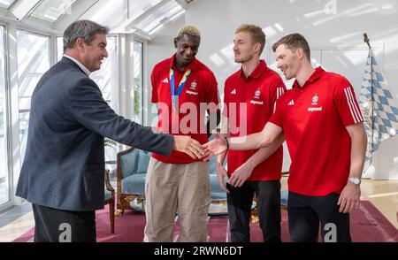 Munich, Allemagne. 20 septembre 2023. Markus Söder, (l, CSU) ministre-président de Bavière, rencontre les trois membres de l'équipe nationale de basket-ball, Isaac Bonga (l-r), Niels Giffey et Andreas Obst. Crédit : Peter Kneffel/dpa/Alamy Live News Banque D'Images