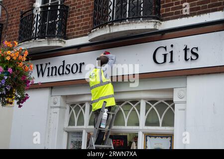 Windsor, Berkshire, Royaume-Uni. 20 septembre 2023. Un préposé à l'entretien remplaçant les lettres à l'extérieur d'une boutique de cadeaux où l'on peut lire Windsor Gits au lieu de Windsor Gifts. Crédit : Maureen McLean/Alamy Banque D'Images