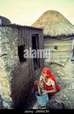 04 03 2020 Femme appliquant le plâtre de boue et de bouse de vache sur le mur de la maison Sri Dungarh Bikaner District Rajasthan Inde Asie. Banque D'Images