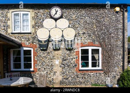 L'horloge Guinness sur le mur de la maison publique Elveden Inn à Elveden sur le bord de la forêt de Thetford. Banque D'Images