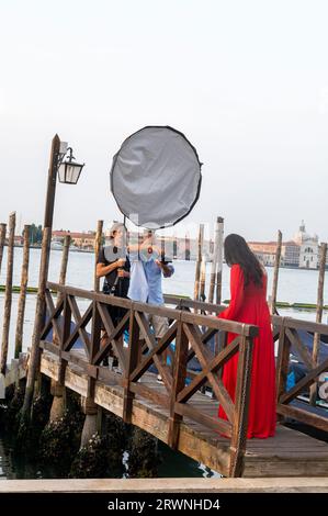 Une séance photo de mode à l'aide d'un flash de studio portable sur un débarcadère sur Marco (place Saint-Marc) dans la région de la Vénétie au nord de l'Italie. Banque D'Images