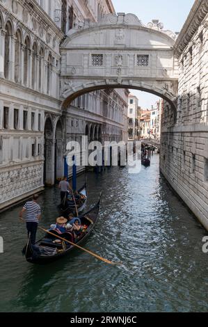 Un gondolier avec sa chemise rayée noire et blanche familière est un rameur qui dirige une gondole avec une longue rame, emmenant les touristes vers le calcaire blanc Banque D'Images