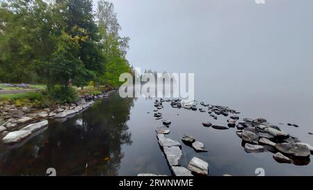 Quand le brouillard du matin essaie de se soulever du lac, et laisser le soleil sortir. Banque D'Images