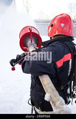 Fireman éteindre l'incendie par projection de mousse flexible. Banque D'Images