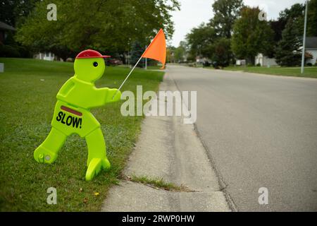 Panneau représentant un homme tenant le drapeau pour avertir les conducteurs de ralentir pour les enfants Banque D'Images