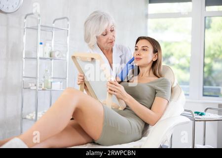 Cosmétologue avec des gants préparant le patient à la procédure de soins de la peau dans le salon de spa. Banque D'Images