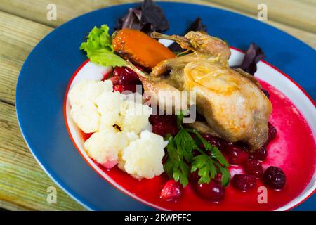 Caille rôtie avec sauce aux canneberges et carottes caramélisées Banque D'Images