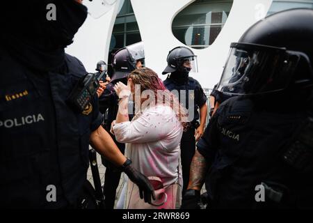 Un congressiste rempli de peinture en poudre rose est escorté par la police pendant le rassemblement. Manifestation contre le congrès du District de Barcelone où se sont rencontrés les principaux investisseurs des États réels à Barcelone. Les activistes bloquent l'entrée et jettent de la peinture en poudre sur les congresistes. (Photo de Pol Cartié/SOPA Images/Sipa USA) crédit : SIPA USA/Alamy Live News Banque D'Images