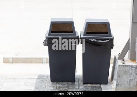 Séparation des déchets deux poubelles noires sont placées dans un lieu public sur le bord de la route en attendant les collecteurs d'ordures pour aider à réduire les déchets, aider global Banque D'Images