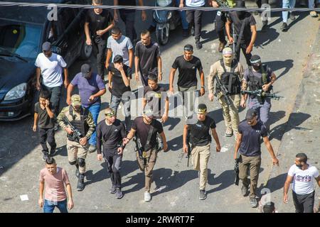 Des hommes armés masqués prennent part aux funérailles de Mahmoud al-Sadi, 23 ans, Mahmoud Ararawi, 24 ans, et ATA Yasser Musa, 29 ans, drapés dans le drapeau du Hamas et du Jihad islamique lors de leurs funérailles dans le camp de réfugiés de Djénine, en Cisjordanie. Les responsables palestiniens de la santé disent que le nombre de morts au cours d'une journée de combats entre Israël et les Palestiniens en Cisjordanie occupée et dans la bande de Gaza est passé à six, dont quatre à Djénine. L'armée a déclaré que les forces ont effectué une frappe rare mardi avec un drone suicide pendant l'opération et ont échangé des tirs avec des hommes armés à Djénine. (Photo de Nasse Banque D'Images