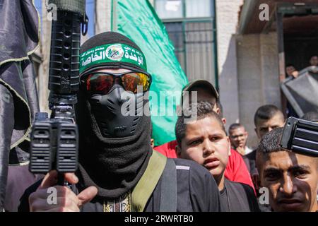 Un tireur masqué prend part aux funérailles de Mahmoud al-Sadi, 23 ans, Mahmoud Ararawi, 24 ans, et ATA Yasser Musa, 29 ans, drapés dans le drapeau du Hamas et du Jihad islamique lors de leurs funérailles dans le camp de réfugiés de Djénine, en Cisjordanie. Les responsables palestiniens de la santé disent que le nombre de morts au cours d'une journée de combats entre Israël et les Palestiniens en Cisjordanie occupée et dans la bande de Gaza est passé à six, dont quatre à Djénine. L'armée a déclaré que les forces ont effectué une frappe rare mardi avec un drone suicide pendant l'opération et ont échangé des tirs avec des hommes armés à Djénine. (Photo de Na Banque D'Images
