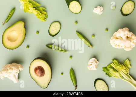 Mise en page créative faite d'avocat, citron vert, brocoli, poivron vert, concombre, piment et courgettes. Pose à plat. Concept alimentaire. Légumes verts isolés Banque D'Images