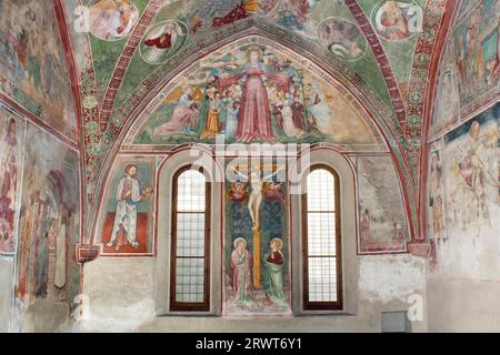 Fresques dans la salle du chœur avec une Madone de Miséricorde, qui protège les différents domaines sociaux sous son manteau, une scène crucifixion de Maestreo di Banque D'Images