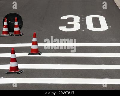 Nouvelle zone de limite de vitesse de 30 km h, l'itinéraire de circulation a été modifié, les symboles ont été peints, les chapeaux de circulation sont sur la route Banque D'Images