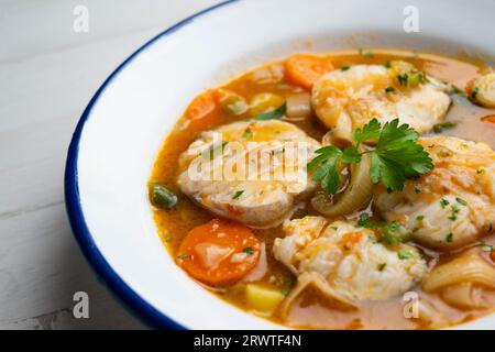 Ragoût de merlu avec pommes de terre, poireaux et autres légumes de saison. Banque D'Images