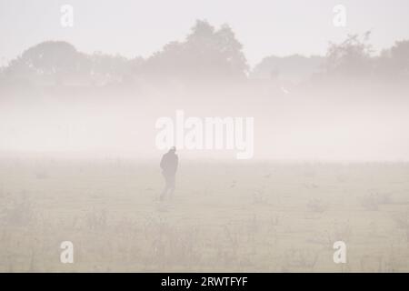 Dorney, Buckinghamshire, Royaume-Uni. 21 septembre 2023. Un homme marchant dans la brume. Après une journée de fortes pluies hier, le matin était brumeux sur Dorney Common dans le Buckinghamshire. Crédit : Maureen McLean/Alamy Live News Banque D'Images