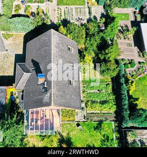 Vue aérienne d'une maison unifamiliale allemande typique sur un terrain utilisé pour le jardinage avec un drone Banque D'Images