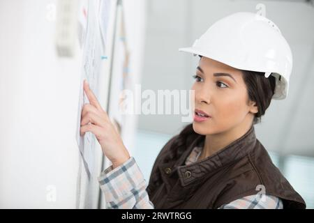 une femme de volonté forte dans un casque de construction Banque D'Images