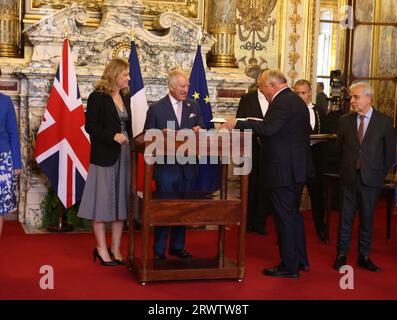 Le roi Charles III, surveillé par le président du Sénat, M. Gérard Larcher, et le Président de l’Assemblée nationale, Mme Yael Braun-Pivet, signant le livre des visiteurs dans la salle des conférences alors qu’il arrive pour s’adresser aux membres du Sénat, au Palais du Luxembourg à Paris, le deuxième jour de la visite d’État en France. C'est la première fois qu'un membre de la famille royale britannique prend la parole depuis la Chambre du Sénat. Date de la photo : jeudi 21 septembre 2023. Banque D'Images