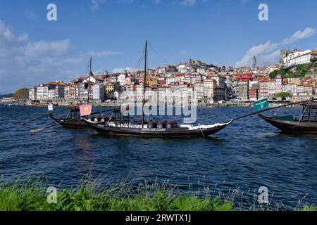 Barils de producteurs de vin de Porto sur des bateaux amarrés le long du fleuve Douro à Porto, Portugal. Banque D'Images