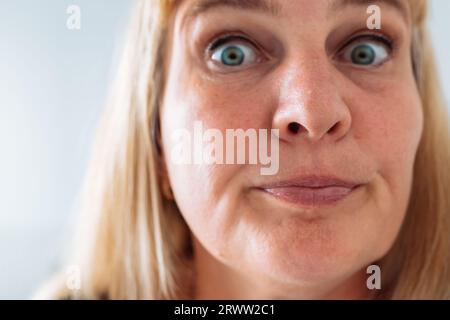 Portrait femme d'âge moyen, blonde, grimacant dans le miroir avant Banque D'Images