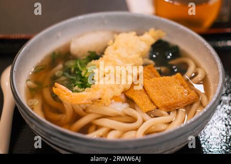 Un gros plan d'un bol avec soupe d'udon japonaise dans un restaurant, prêt à manger Banque D'Images