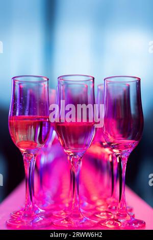 Une image de nature morte d'une paire de verres à vin assis sur un tissu rose sur une table Banque D'Images