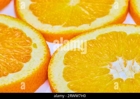 Gros plan lumineux de trois tranches orange avec centre charnu et fond blanc Banque D'Images