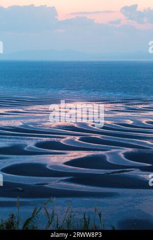 Sand pattern of Mikoshiorai Coast, the setting sun, and the sea Stock Photo