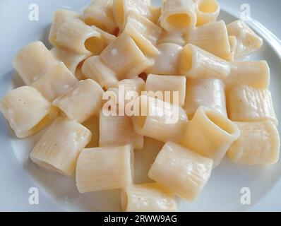 Assiette de pâtes italiennes Penne avec une sauce salée crémeuse formaggio et basilic servie dans un menu noir plat bleu Banque D'Images