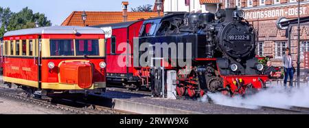 21 septembre 2023, Mecklembourg-Poméranie occidentale, Kühlungsborn : le wagon T1 du Borkumer Kleinbahn, appelé «Schweineschnäuzchen», se trouve à côté d'un train de voyageurs avec locomotive à vapeur dans la gare pour le voyage d'ouverture sur la ligne à voie étroite du Kleinbahn Molli. Du 21.09.2023 au 01.10.2023, le bus ferroviaire, construit en 1940 à l'usine de wagons Wismar, circulera sur le réseau de voies à écartement étroit de 900 mm du Mecklembourg Bäderbahn Molli. Photo : Jens Büttner/dpa Banque D'Images