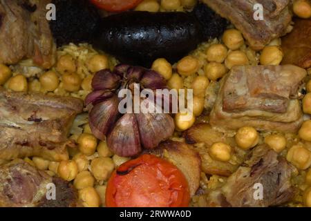 Détail d'une casserole de riz prête à cuire typique de Xativa (Valencia) avec ail, riz, pois chiches, porc, tomate, pommes de terre... Banque D'Images