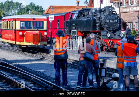 21 septembre 2023, Mecklembourg-Poméranie occidentale, Kühlungsborn : des fans de chemin de fer prennent une photo du wagon T1 du Borkumer Kleinbahn, le soi-disant 'Schweineschnäuzchen', debout à côté d'un train de voyageurs avec locomotive à vapeur dans la gare pour le voyage d'ouverture sur la ligne à voie étroite du Kleinbahn Molli. Du 21.09.2023 au 01.10.2023, le bus ferroviaire construit en 1940 à l'usine de wagons Wismar sera sur le réseau à voie étroite de 900 mm du Mecklenburg Bäderbahn Molli. Photo : Jens Büttner/dpa Banque D'Images