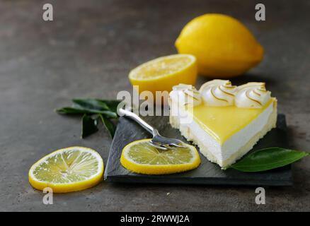 tarte au citron avec meringue et citrons frais sur la table Banque D'Images