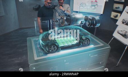 Deux ingénieurs automobiles masculins développent une nouvelle voiture électrique écologique en utilisant un prototype d'automobile holographique futuriste en réalité augmentée. Graphiques 3D du développement high-tech du véhicule. Animation VFX. Banque D'Images