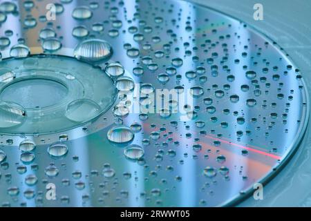 Surface bleu calme et argent avec des gouttelettes d'eau argentées sur la surface CD et fond bleu ardoise Banque D'Images