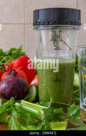 Faire un smoothie de légumes avec des légumes frais dans un mélangeur. Alimentation santé et concept vivant. Banque D'Images