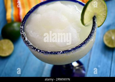 margarita congelée dans un verre bleu salé à bordure avec une tranche de citron vert Banque D'Images